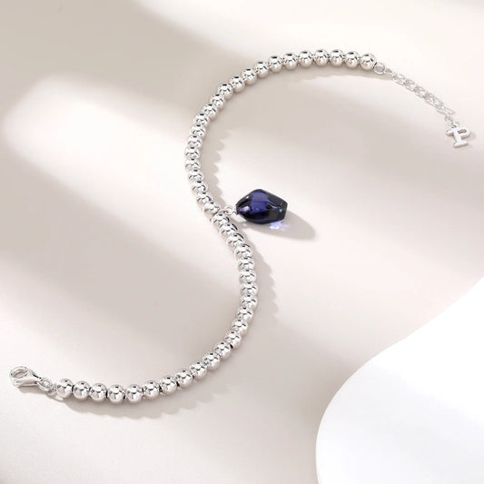 S925 sterling silver spherical bead bracelet featuring a suspended organic freeform charm in a deep royal blue hue.