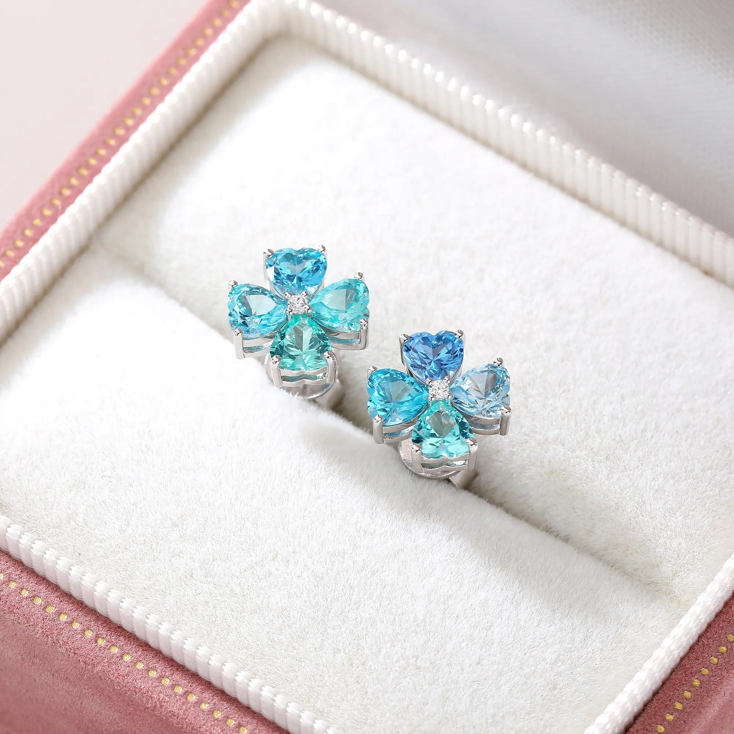 S925 sterling silver stud earrings featuring four heart-cut ocean blue moissanite gemstones forming a lucky four-leaf clover with a sparkling center moissanite.