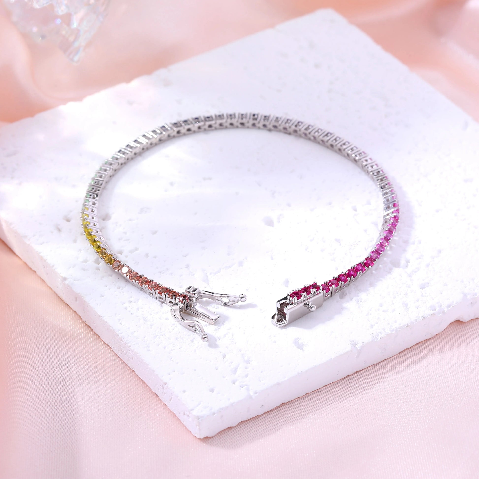 S925 sterling silver tennis bracelet featuring a continuous gradient line of 3.0mm round cut colorful rainbow sapphires with a secure box clasp.