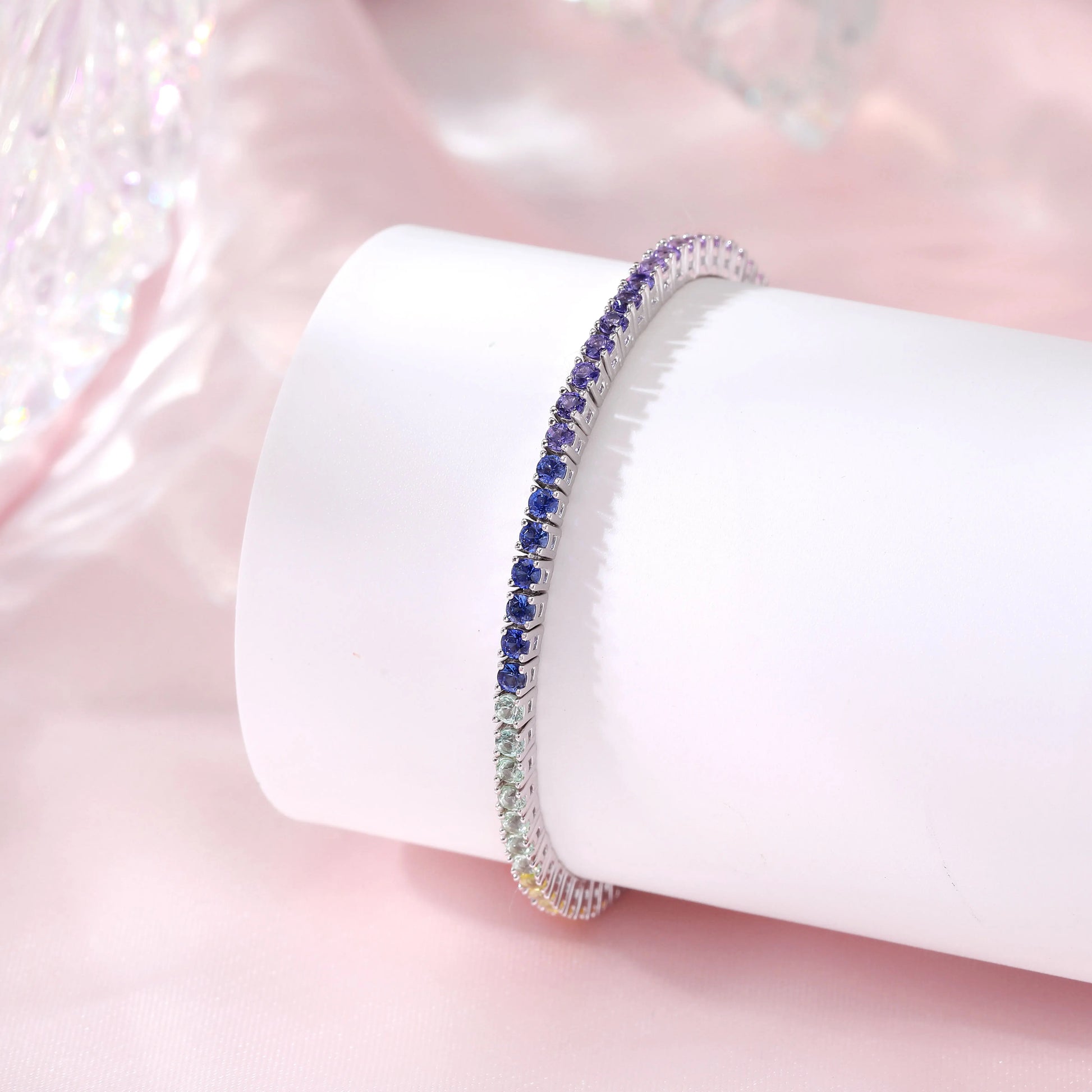 S925 sterling silver tennis bracelet featuring a continuous gradient line of 3.0mm round cut colorful rainbow sapphires with a secure box clasp.