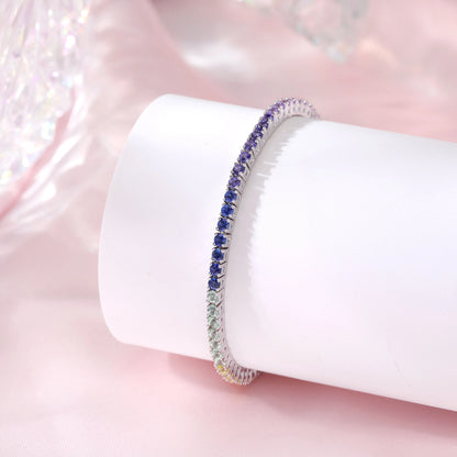 S925 sterling silver tennis bracelet featuring a continuous gradient line of 3.0mm round cut colorful rainbow sapphires with a secure box clasp.