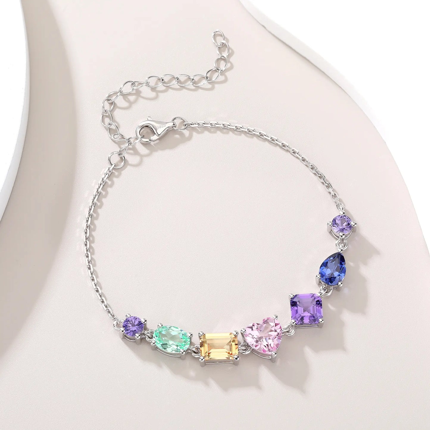 S925 sterling silver chain bracelet featuring seven multi-color and fancy-cut gemstones including heart, pear, emerald, and round shapes.