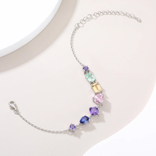 S925 sterling silver chain bracelet featuring seven multi-color and fancy-cut gemstones including heart, pear, emerald, and round shapes.