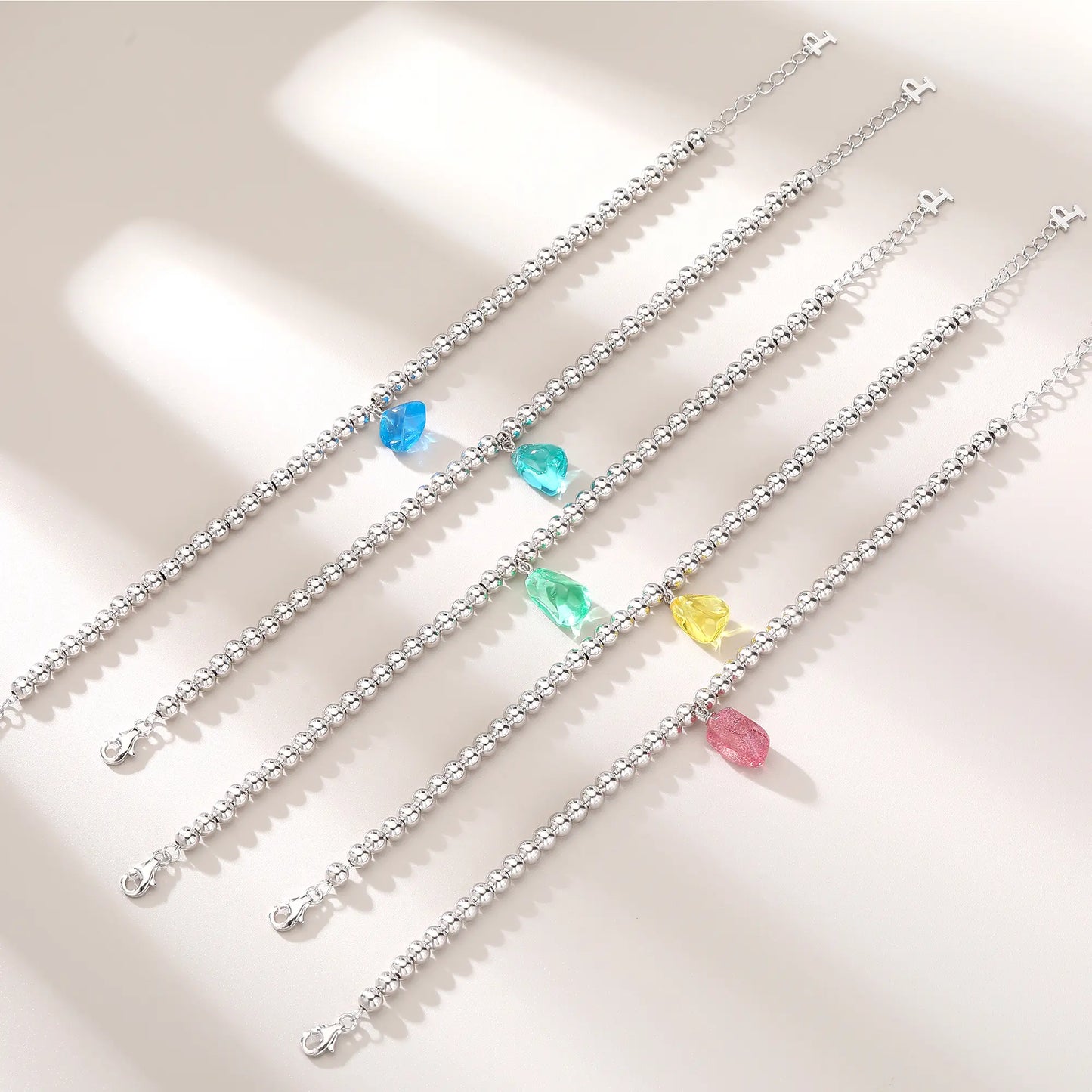 S925 sterling silver beaded bracelet featuring polished round silver beads and a translucent yellow sapphire freeform pendant charm.