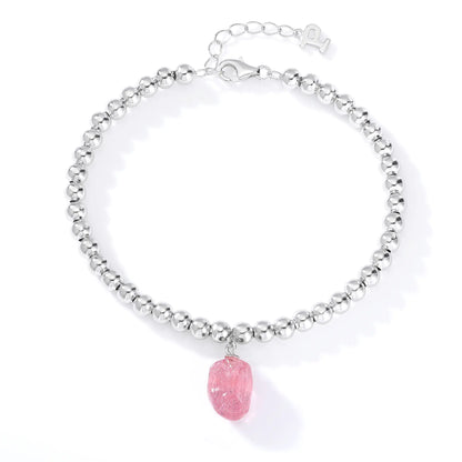 Polished sterling silver spherical bead bracelet featuring a translucent blush-pink freeform gemstone charm with delicate organic textures.