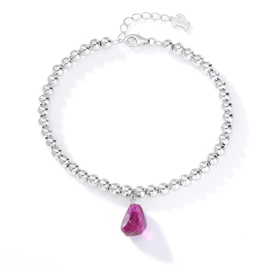 Silver beaded bracelet with a glossy finish featuring a suspended freeform magenta-purple gemstone pendant charm.