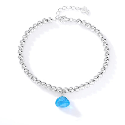 A polished sterling silver spherical bead bracelet featuring a vibrant aqua-blue freeform gemstone charm hanging at the center