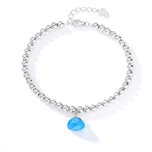 A polished sterling silver spherical bead bracelet featuring a vibrant aqua-blue freeform gemstone charm hanging at the center