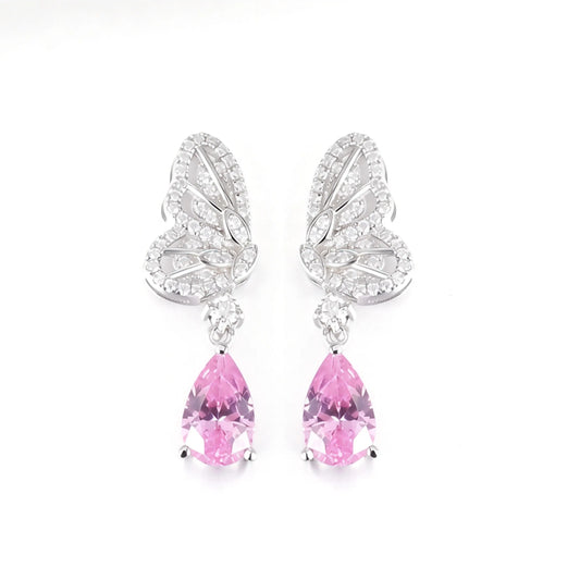 Elegant sterling silver dangle earrings featuring detailed pavé butterfly wings holding vibrant pear-cut pink sapphire stones that catch the light beautifully.