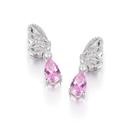 Elegant sterling silver dangle earrings featuring detailed pavé butterfly wings holding vibrant pear-cut pink sapphire stones that catch the light beautifully.