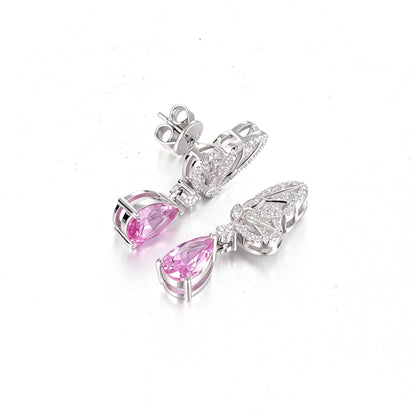 Elegant sterling silver dangle earrings featuring detailed pavé butterfly wings holding vibrant pear-cut pink sapphire stones that catch the light beautifully.