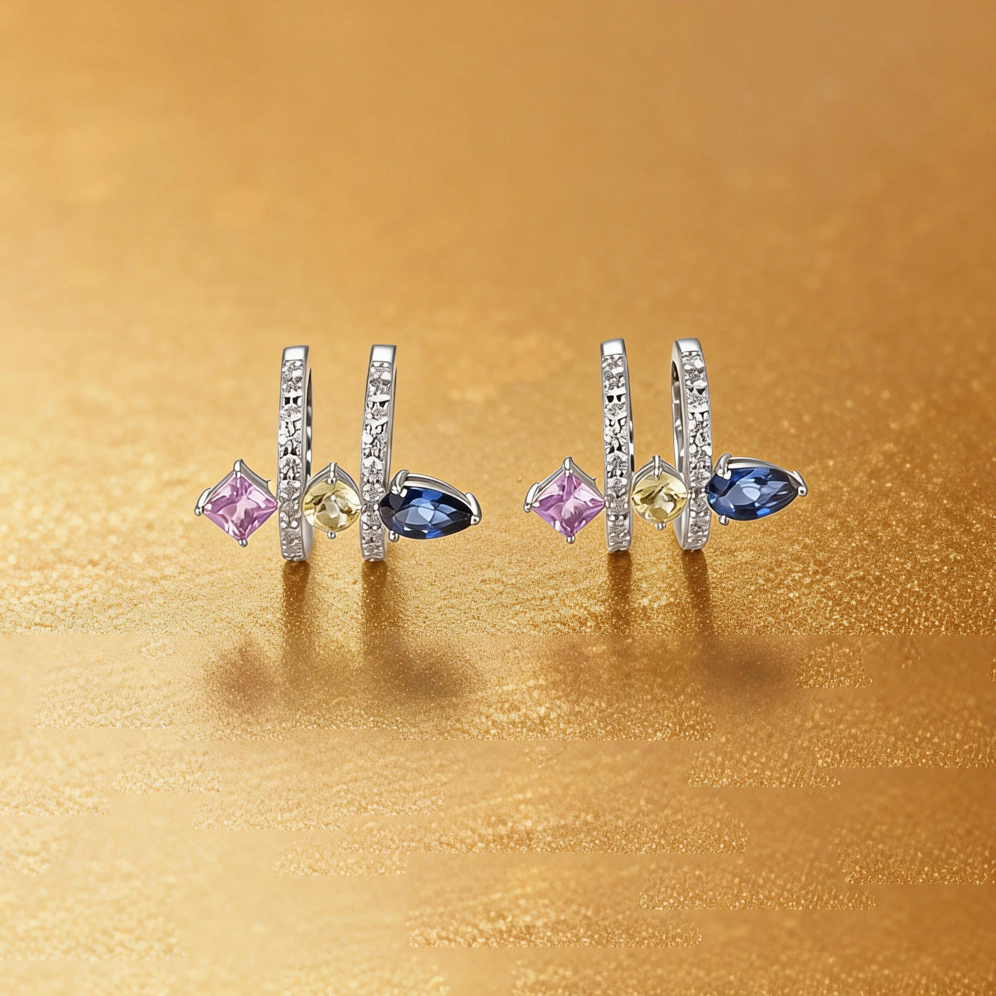 S925 sterling silver double row huggie hoop earrings featuring three geometric gemstones—a blue pear-cut, yellow round-cut, and purple princess-cut stone—with sparkling micro-pavé accents, creating a multi-piercing illusion.