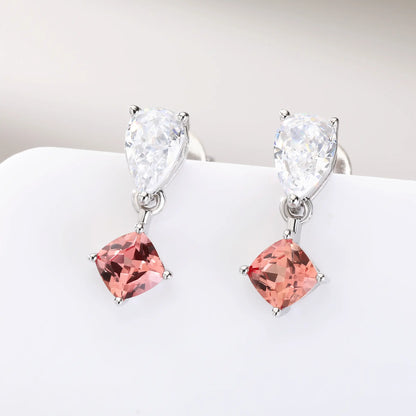 S925 sterling silver drop earrings featuring a sparkling white pear-cut moissanite at the post, dangling a square cushion-cut pink sapphire suspended by a minimalist geometric silver loop.