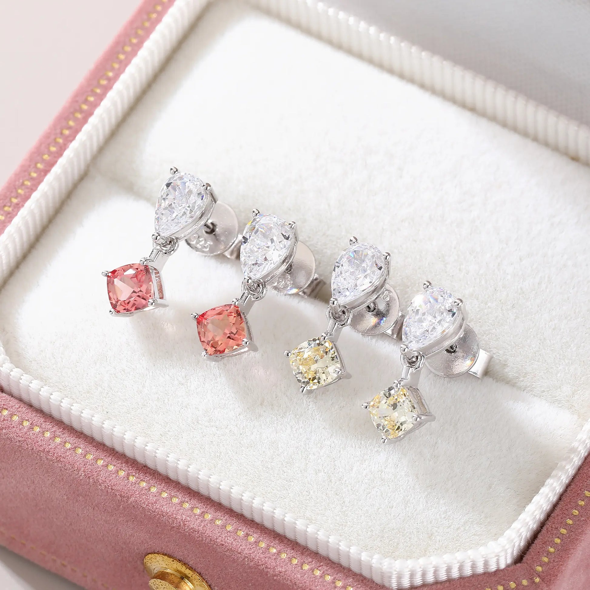 S925 sterling silver drop earrings featuring a sparkling white pear-cut moissanite at the post, dangling a square cushion-cut pink sapphire suspended by a minimalist geometric silver loop.