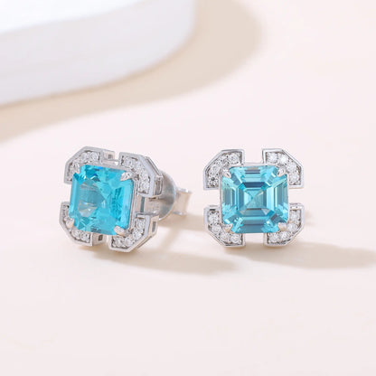 S925 sterling silver geometric stud earrings featuring a square Asscher-cut blue topaz surrounded by an octagonal frame with pavé moissanite accents.