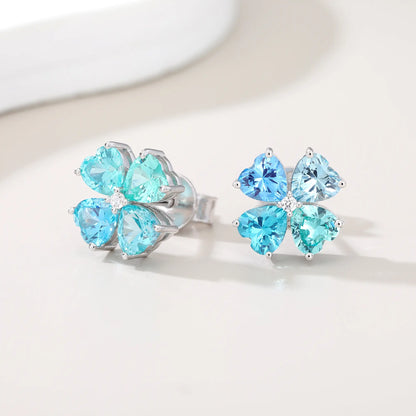 S925 sterling silver stud earrings featuring four heart-cut ocean blue moissanite gemstones forming a lucky four-leaf clover with a sparkling center moissanite.