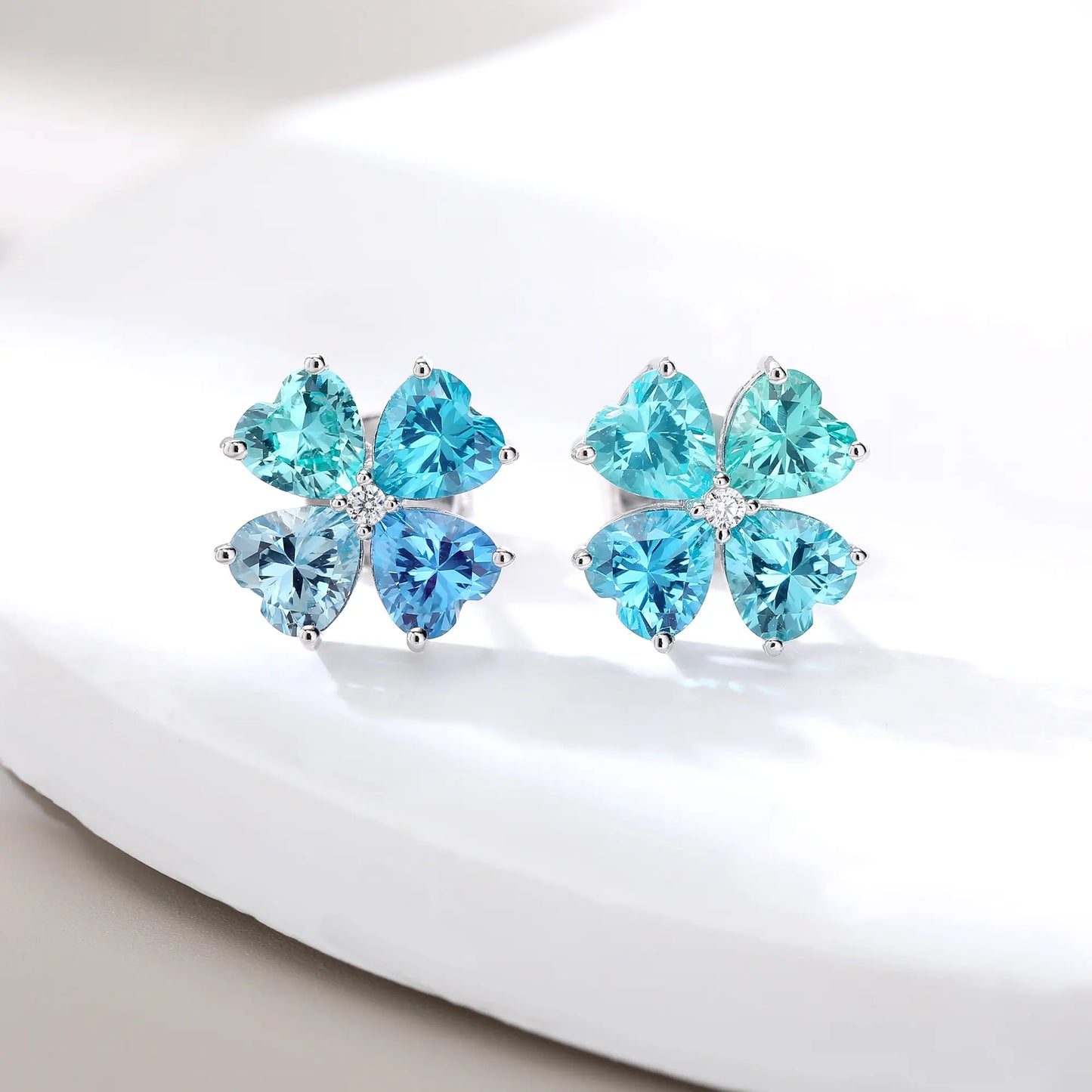 S925 sterling silver stud earrings featuring four heart-cut ocean blue moissanite gemstones forming a lucky four-leaf clover with a sparkling center moissanite.
