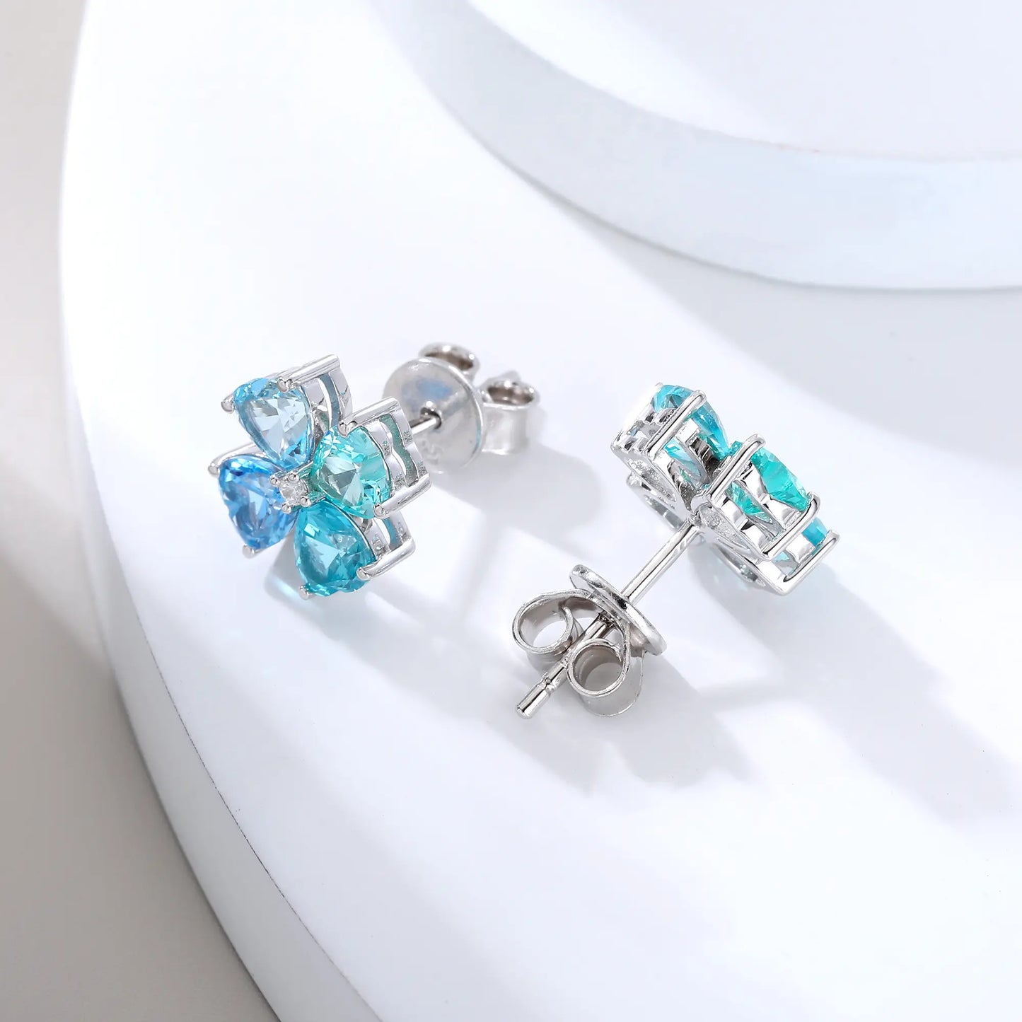 S925 sterling silver stud earrings featuring four heart-cut ocean blue moissanite gemstones forming a lucky four-leaf clover with a sparkling center moissanite.