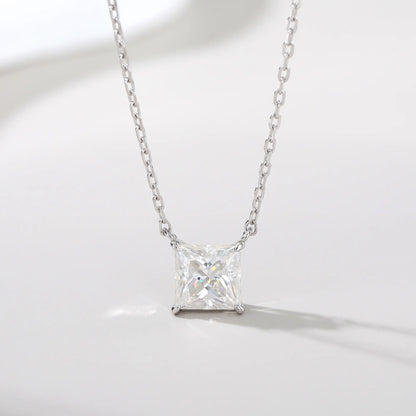 A sparkling princess cut moissanite solitaire pendant necklace in a classic sterling silver four-prong setting, showcasing intense fire and a white reflective surface.