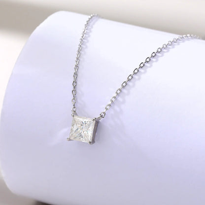 A sparkling princess cut moissanite solitaire pendant necklace in a classic sterling silver four-prong setting, showcasing intense fire and a white reflective surface.