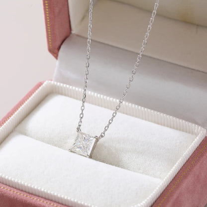 A sparkling princess cut moissanite solitaire pendant necklace in a classic sterling silver four-prong setting, showcasing intense fire and a white reflective surface.