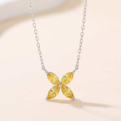 A sterling silver chain necklace featuring a classic minimalist four-leaf clover flower pendant crafted with four brilliant marquise-cut yellow moissanite gemstones.