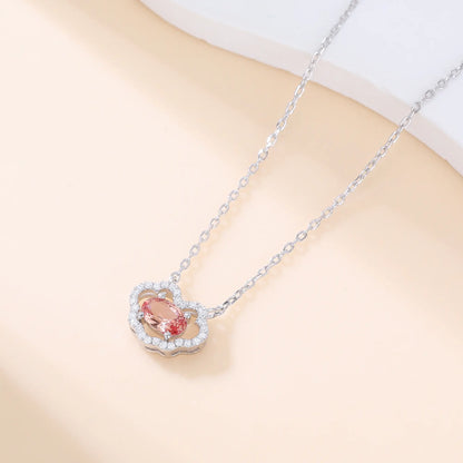 A sterling silver chain necklace featuring a traditional Chinese auspicious Ruyi cloud pendant, encrusted with pavé accents and centered with an oval-cut padparadscha sapphire.