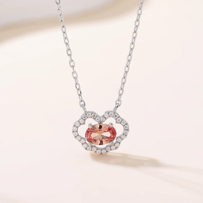 A sterling silver chain necklace featuring a traditional Chinese auspicious Ruyi cloud pendant, encrusted with pavé accents and centered with an oval-cut padparadscha sapphire.