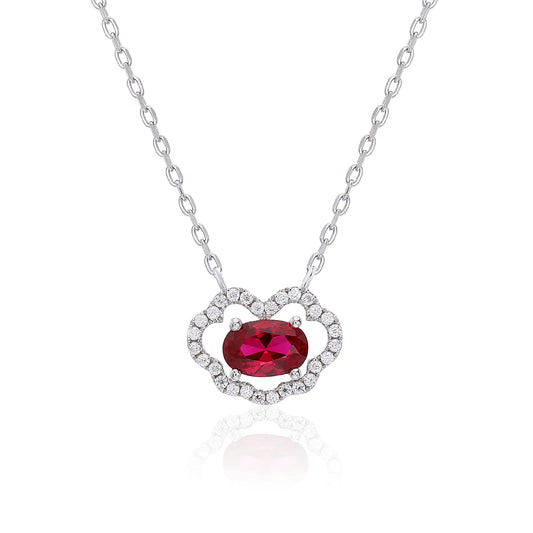 A sterling silver chain necklace featuring a traditional Chinese auspicious Ruyi cloud pendant, encrusted with pavé accents and centered with a vibrant oval-cut red ruby gemstone.