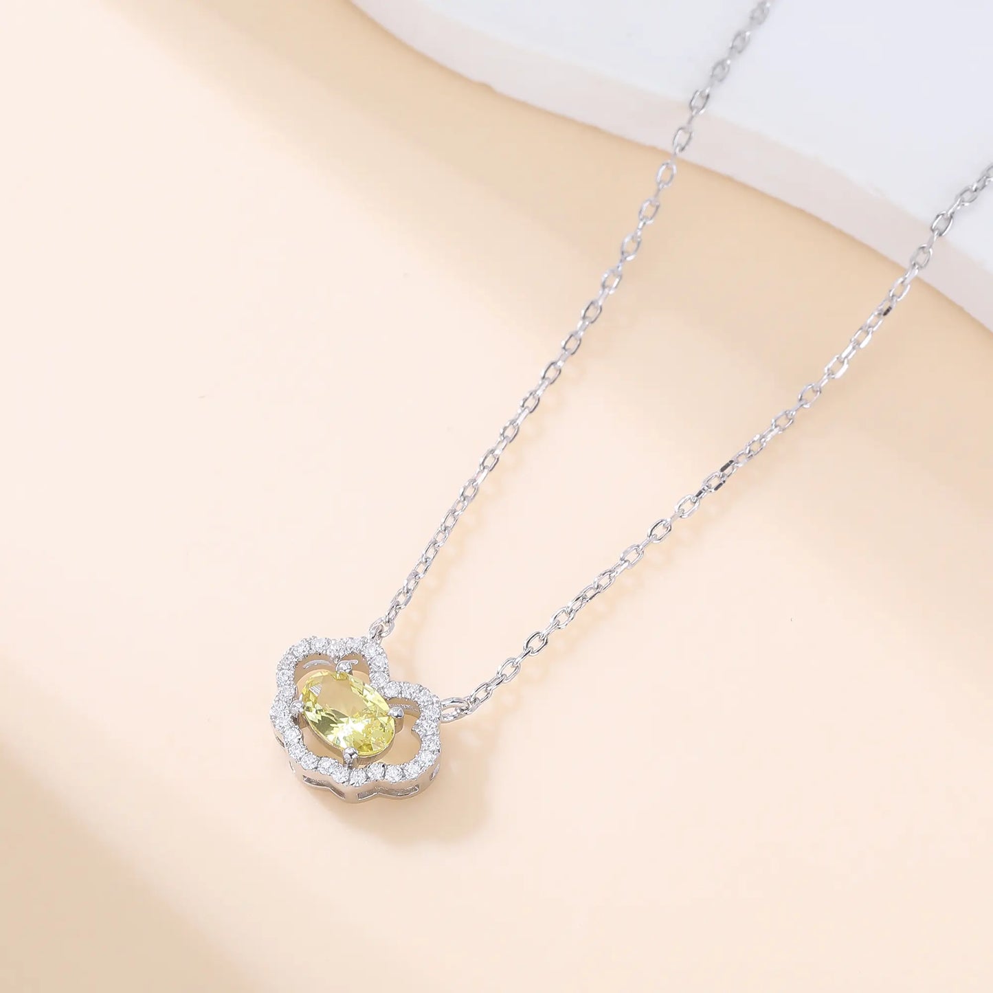 A sterling silver chain necklace featuring a traditional Chinese auspicious Ruyi cloud pendant, encrusted with shimmering pavé accents and centered with an oval-cut yellow moissanite gemstone.