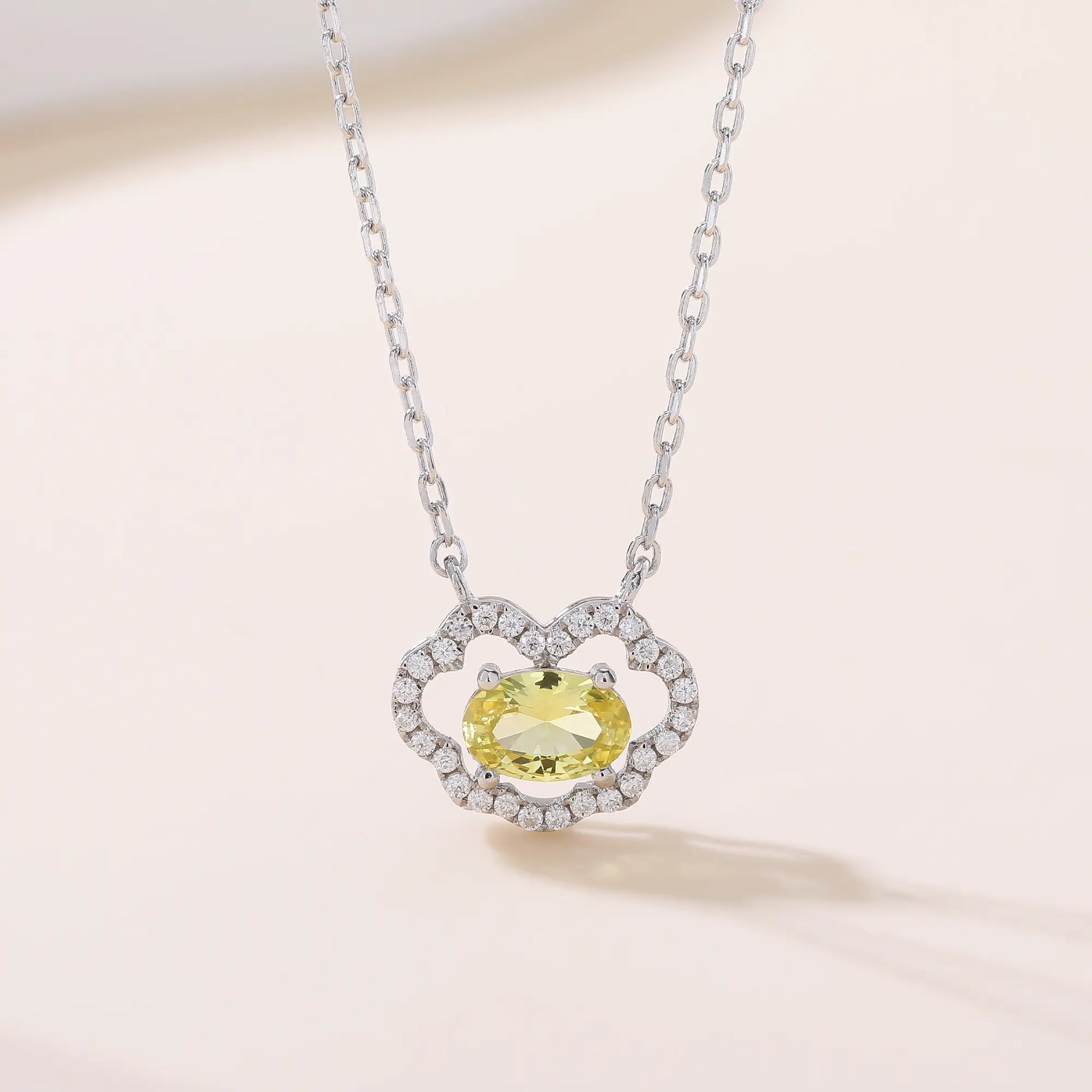 A sterling silver chain necklace featuring a traditional Chinese auspicious Ruyi cloud pendant, encrusted with shimmering pavé accents and centered with an oval-cut yellow moissanite gemstone.