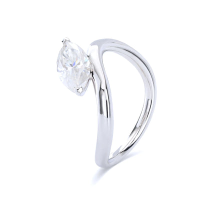 A sterling silver solitaire ring featuring a brilliant marquise-cut white moissanite stone, nestled within a modern fluid bypass twisted wave band.