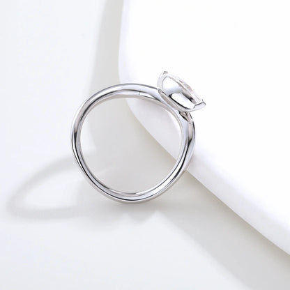 A sterling silver solitaire ring featuring a brilliant marquise-cut white moissanite stone, nestled within a modern fluid bypass twisted wave band.