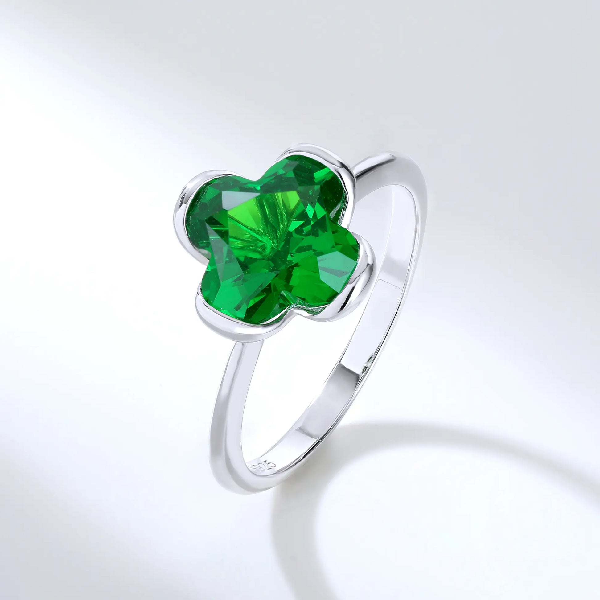 S925 sterling silver ring featuring a single clover-cut vibrant green lab-grown emerald set in a sleek bezel mounting.