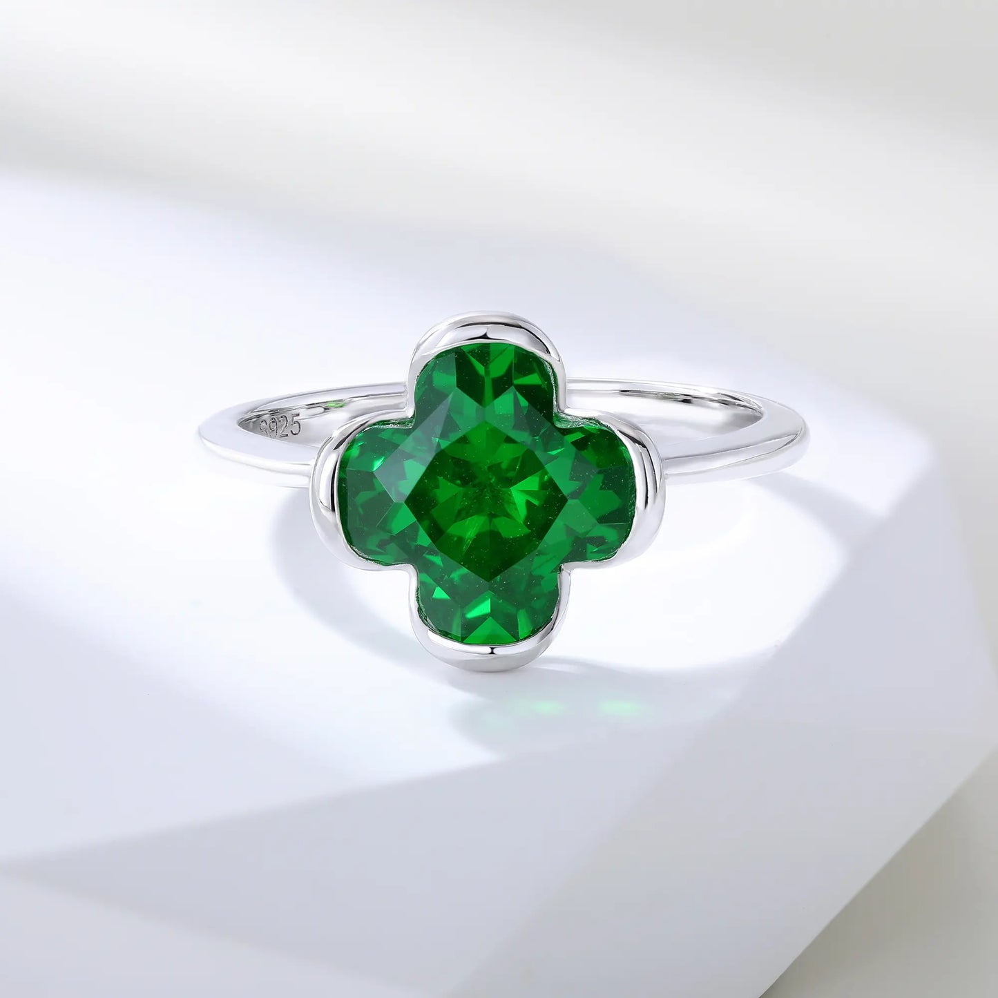 S925 sterling silver ring featuring a single clover-cut vibrant green lab-grown emerald set in a sleek bezel mounting.