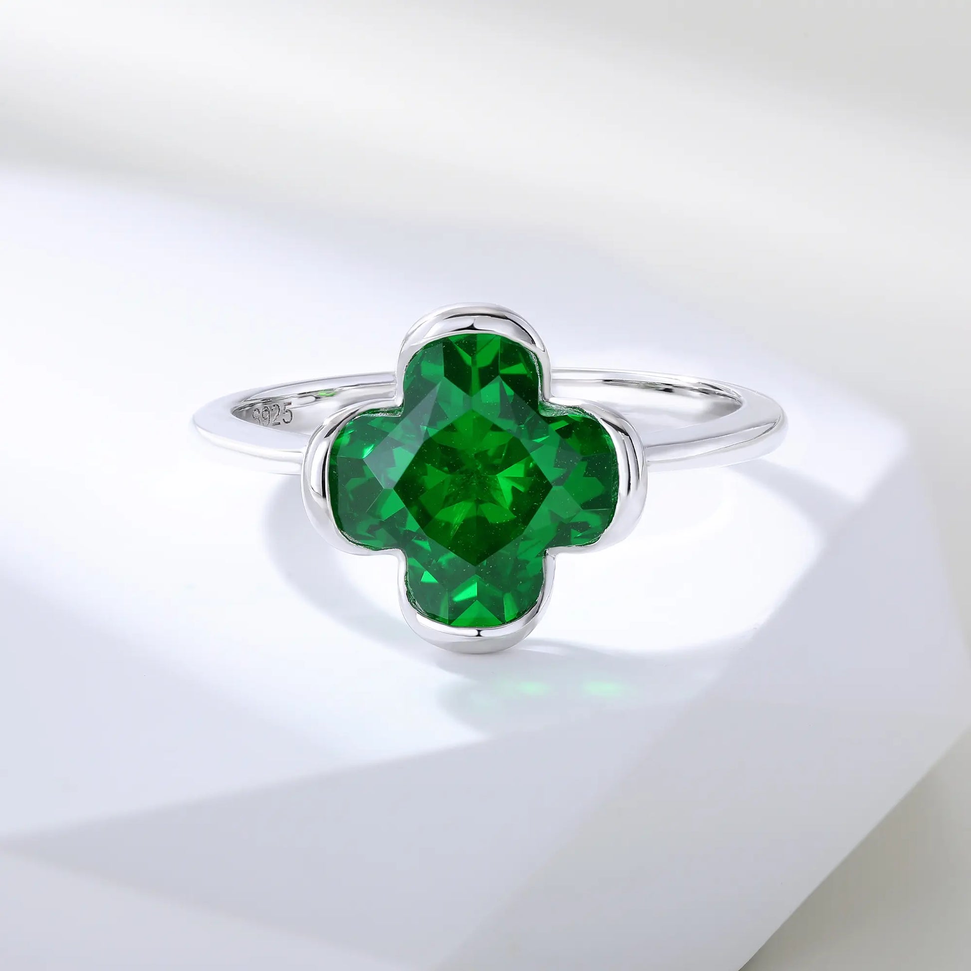 S925 sterling silver ring featuring a single clover-cut vibrant green lab-grown emerald set in a sleek bezel mounting.