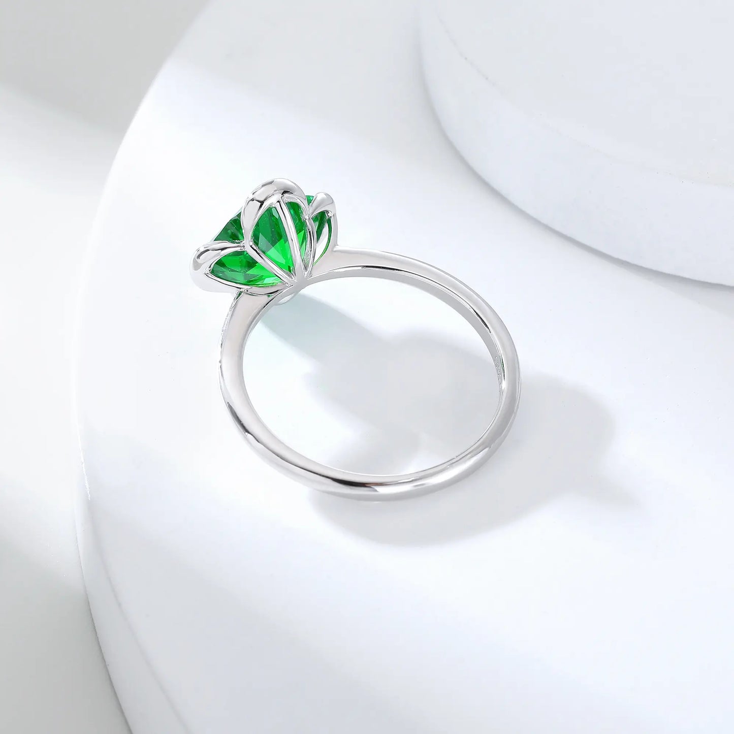 S925 sterling silver ring featuring a single clover-cut vibrant green lab-grown emerald set in a sleek bezel mounting.