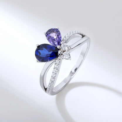 S925 sterling silver criss-cross ring with pear-cut royal blue and lavender sapphires forming a butterfly with a sparkling accent at the center.