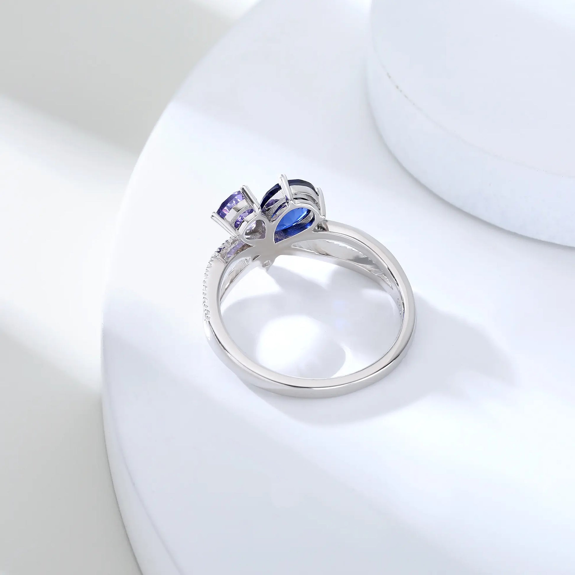 S925 sterling silver criss-cross ring with pear-cut royal blue and lavender sapphires forming a butterfly with a sparkling accent at the center.
