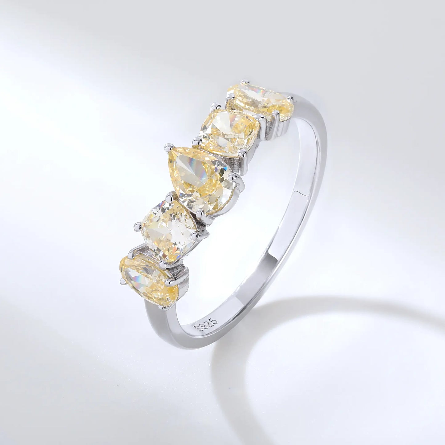 S925 sterling silver five-stone ring featuring fancy multi-shape yellow moissanites including pear, cushion, and oval cuts in a contour band.