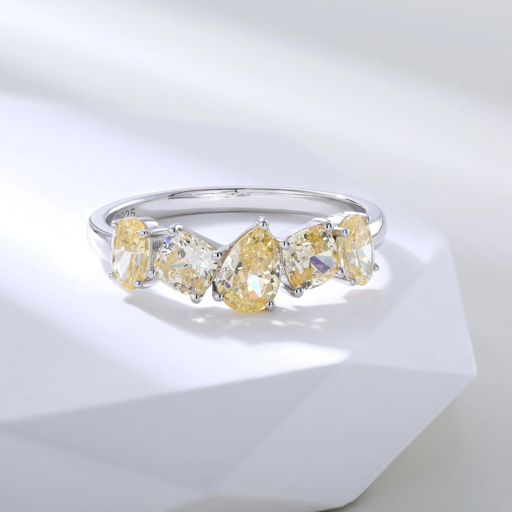 S925 sterling silver five-stone ring featuring fancy multi-shape yellow moissanites including pear, cushion, and oval cuts in a contour band.
