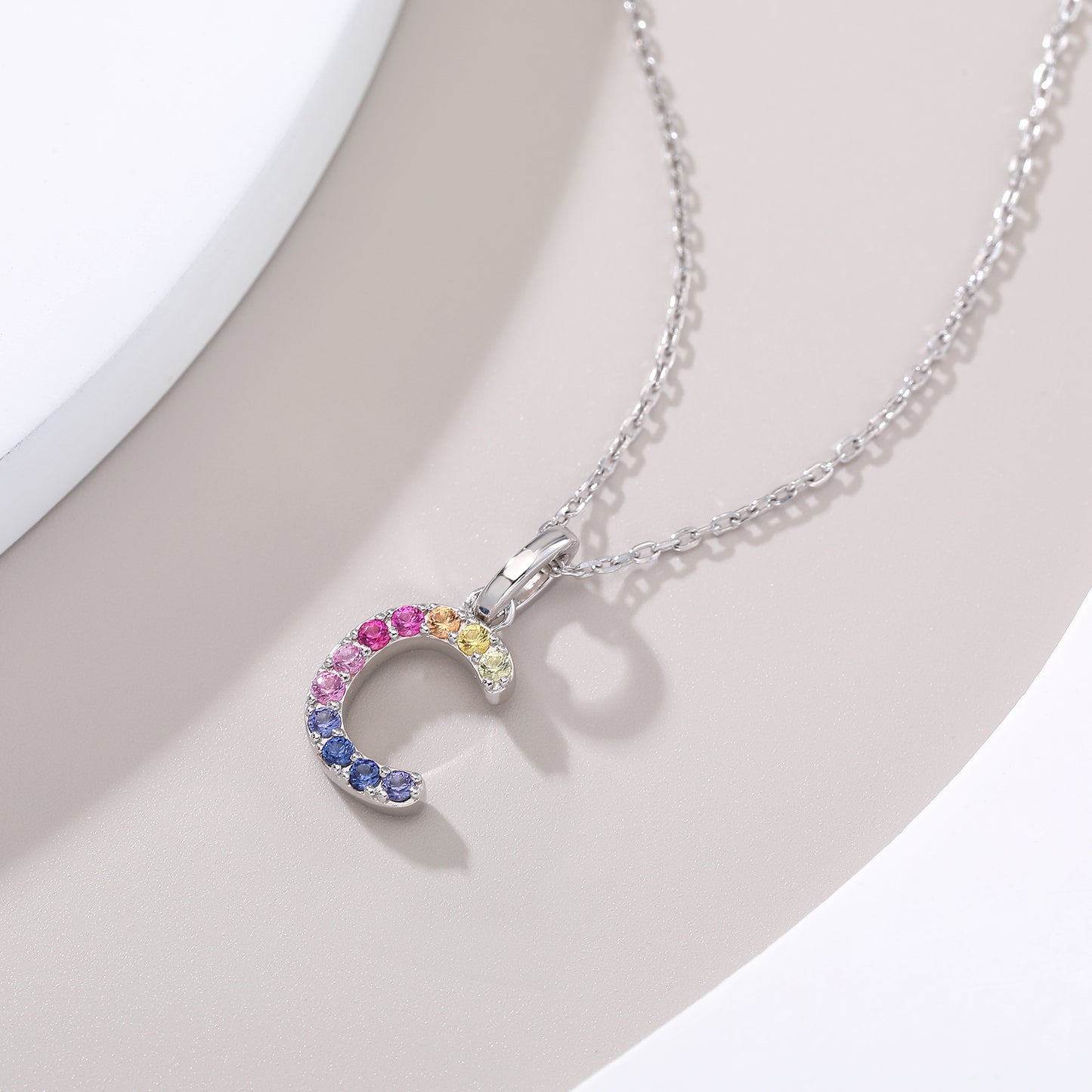 Vibrant multi-color lab-grown sapphire letter C pendant on a sterling silver chain necklace.