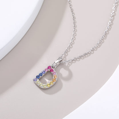 Sterling silver initial necklace showcasing a letter D charm handset with a rainbow gradient of multi-color lab sapphires.