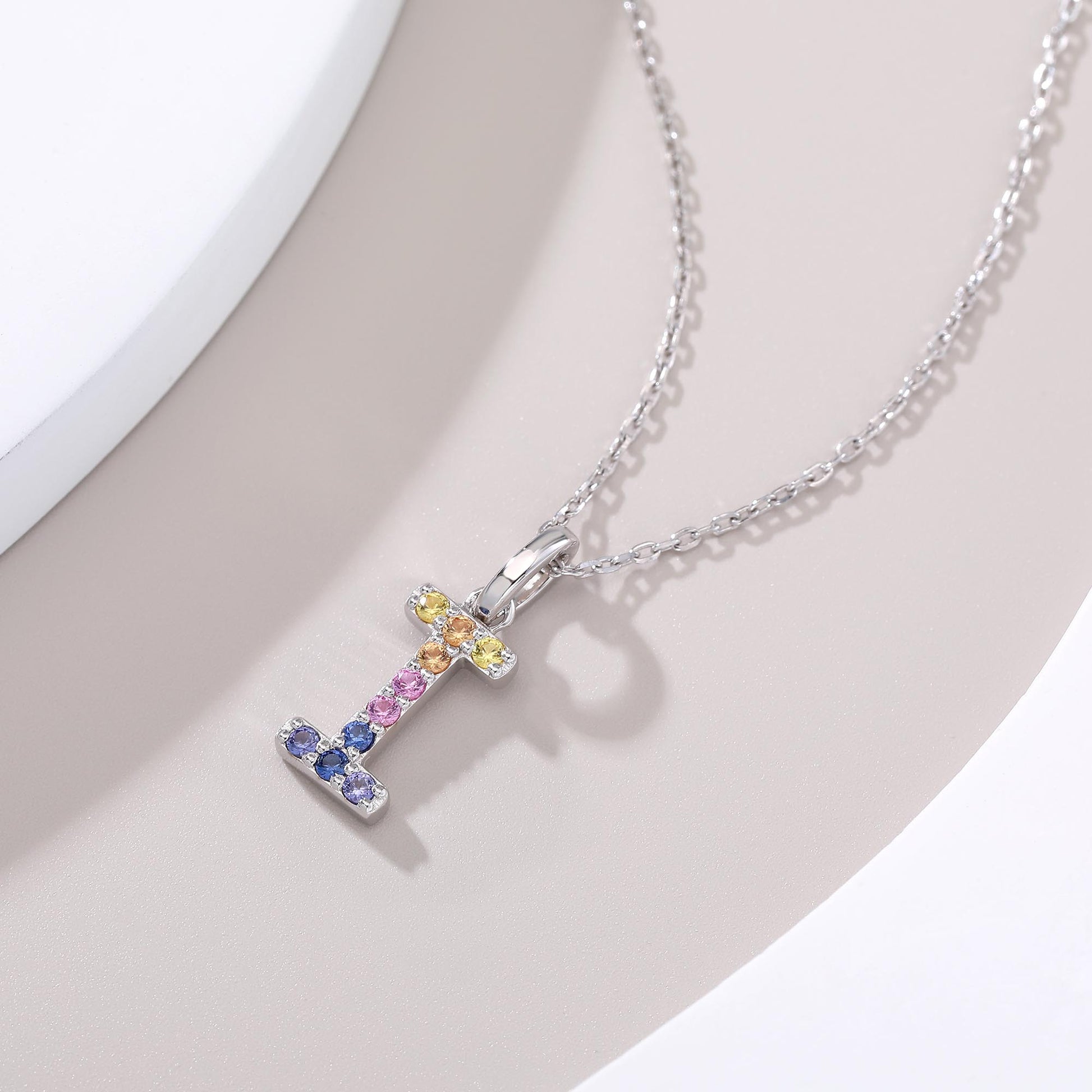 A sleek sterling silver initial necklace showcasing a capital letter I pendant set with a precise vertical rainbow gradient of multi-color lab sapphires.