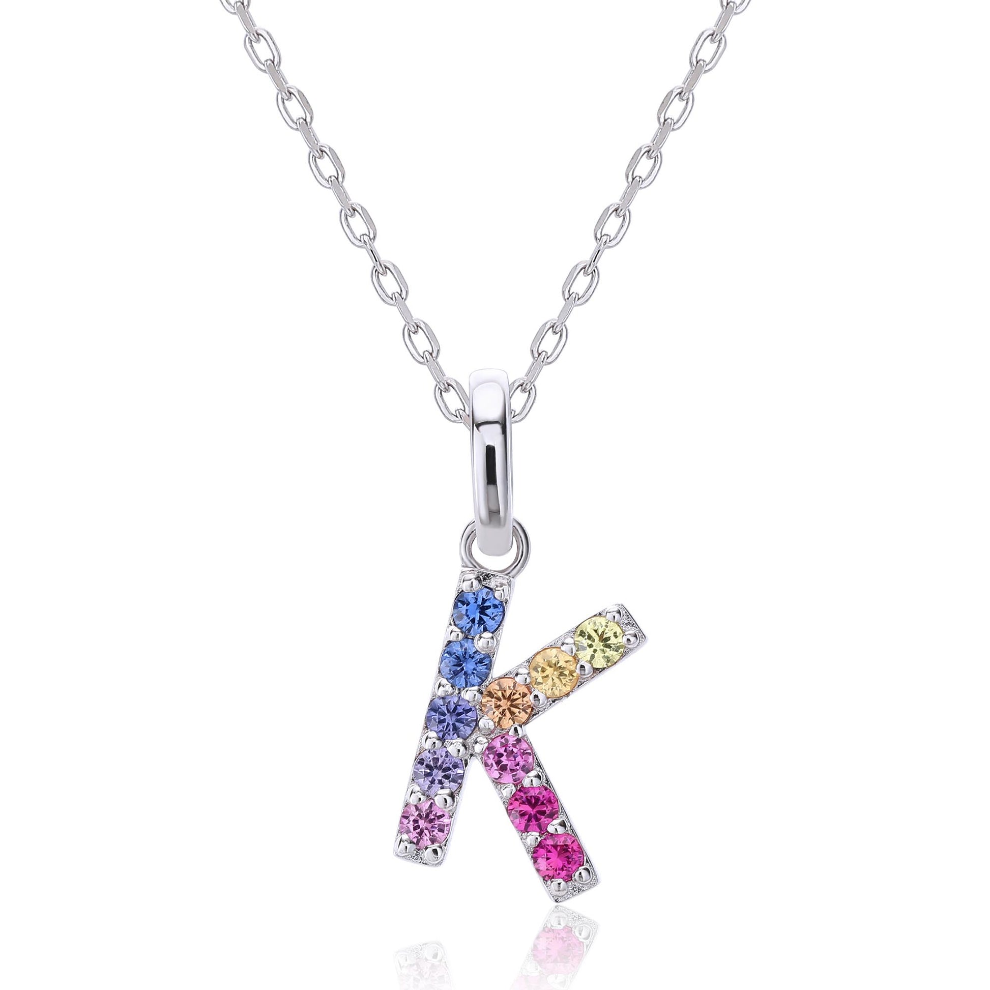A solid sterling silver necklace displaying a sharp letter K pendant prong-set with a striking multi-color rainbow gradient of brilliant lab sapphires.