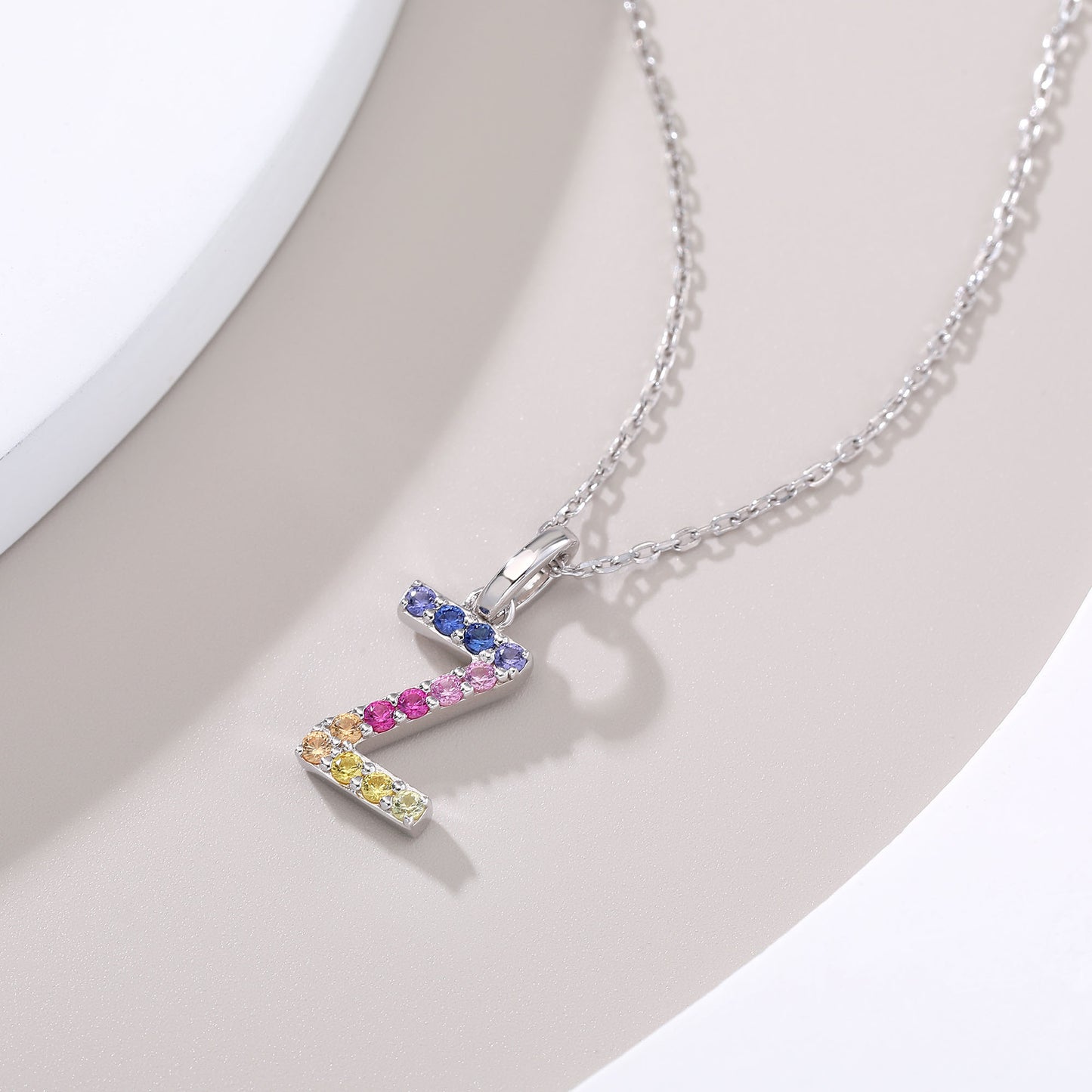 A delicate sterling silver cable chain secure with a modern uppercase letter Z pendant, beautifully adorned with a continuous micro-pave wave of multi-colored round lab-grown sapphires.